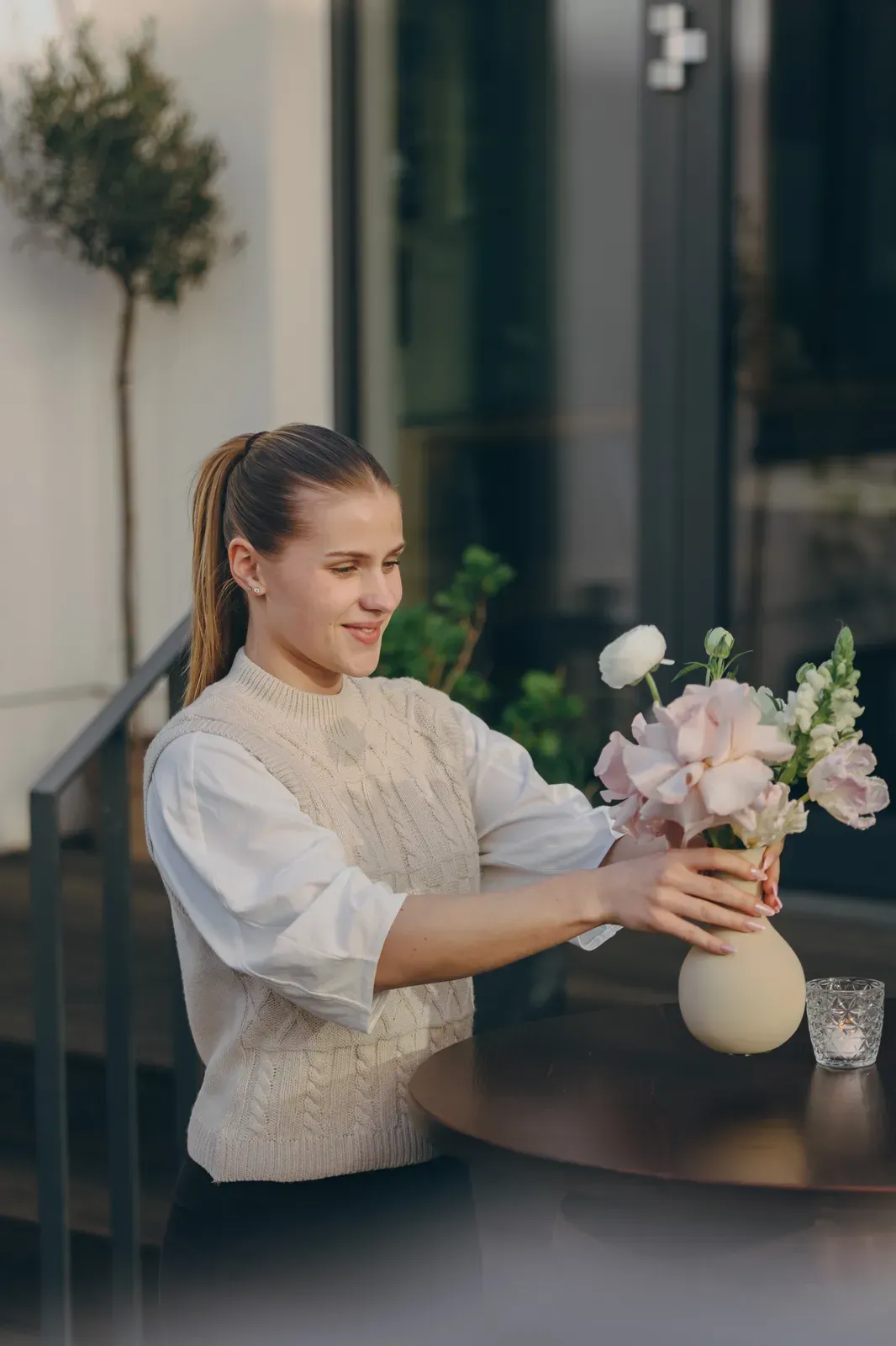 Floristin stellt einen hellen Blumenstrauß in eine Vase